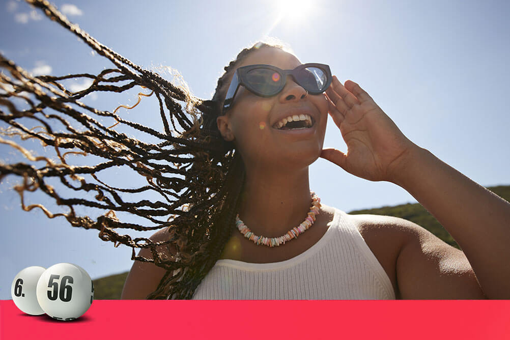 Mujer sonriendo después de ver cuáles son los números más sorteados del Melate en Lottoland.